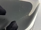 a person standing in a bathtub with a black umbrella
