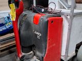 un chariot élévateur rouge et noir garé dans un entrepôt