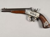 an old gun with a wooden handle on a white surface
