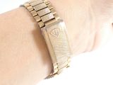 a woman ' s wrist that has a gold watch on it
