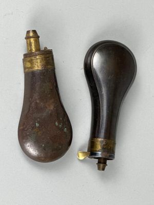une paire de poignées de porte anciennes en laiton et en bois sur un fond blanc