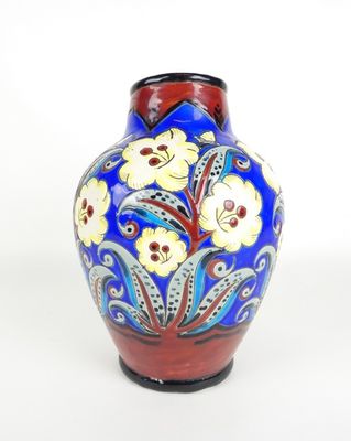 un vase bleu orné de fleurs jaunes sur fond blanc