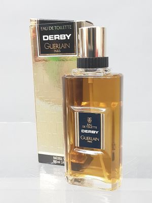 Le flacon de parfum se trouve à côté de la boîte, sur la table.