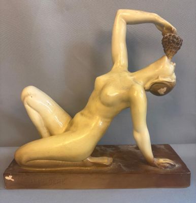 statue représentant une femme allongée sur le ventre sur un socle en bois