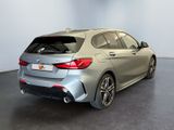 the rear end of a silver bmw car in a showroom