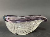 purple and white glass bird sitting on top of a white net