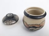 a small pot with a lid sitting next to a smaller pot