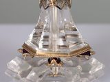 a crystal candle holder on a table with a clock on it