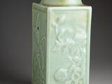 a green vase with a design on it on a table