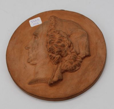 une image représentant une plaque en argile sur laquelle figurent une femme et un chien