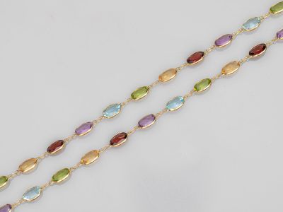 un gros plan d'un collier multicolore posé sur une surface blanche