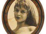 une vieille photo d'une femme aux cheveux longs, dans un cadre en bois