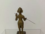 bronze figurine of a man holding a sword on a glass table