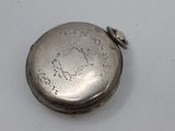 a small silver pocket watch on a white surface