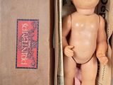 a small doll in a box with a cloth on it