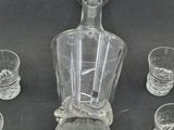 a glass bottle and glasses sitting on a table