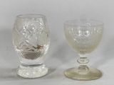 two glass goblets sitting next to each other on a table