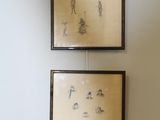 two framed pictures hanging on the wall above a toilet
