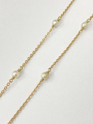 a gold chain with pearls on it