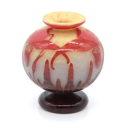 un vase rouge et blanc posé sur un socle en bois