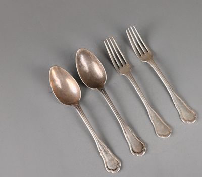 four silver spoons and a fork on a gray surface