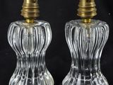 two clear glass salt and pepper shakers with brass tops