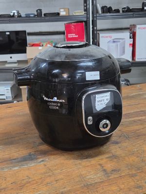 une friteuse à air chaud noire posée sur une table en bois