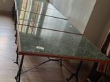 une longue table avec un plateau en verre au milieu d'une pièce