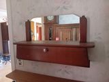 un miroir accroché au mur au-dessus d'une étagère sur laquelle se trouve un miroir