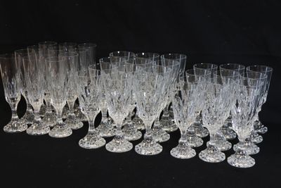 twelve crystal wine glasses lined up in a row on a black background
