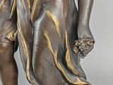 an antique bronze statue of a boy and a girl holding flowers