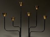 une image représentant un chandelier noir et doré à cinq bougies