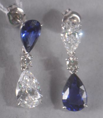 pair of sapphire and diamond earrings on display in a glass case