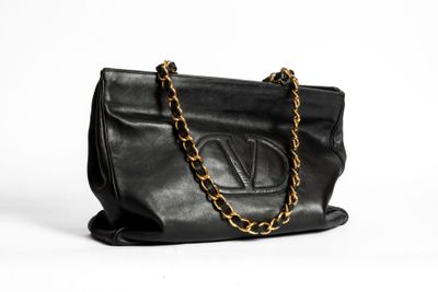 a black leather handbag with a gold chain strap