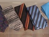 six different ties in a clear box on a table