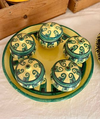 une assiette de cupcakes posée sur une table à côté d'un bol d'oranges