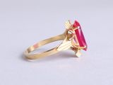 a close up of a gold ring with a pink stone
