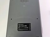 a silver electronic device sitting on a white surface