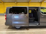 a silver van parked in a parking lot with its doors open