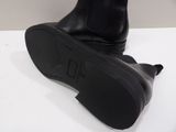 black leather boots on a white surface with a white background