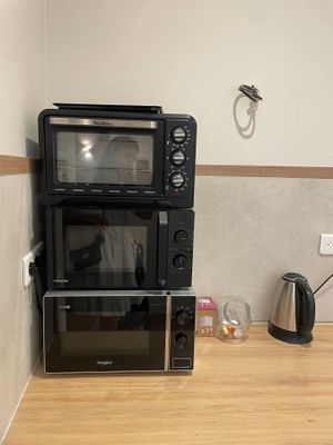 deux micro-ondes et un four grille-pain sur le plan de travail de la cuisine