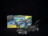 a batman batmobile toy next to a box of batmobiles