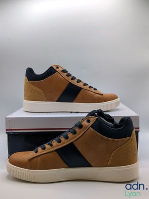a pair of brown and black sneakers on top of a box