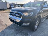 the black ford ranger is parked in a parking lot