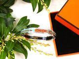 two bracelets sitting in a box next to a plant