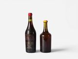 two bottles of beer sitting next to each other on a white surface