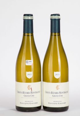 deux bouteilles de vin blanc posées l'une à côté de l'autre sur une surface blanche