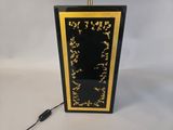 a black and gold lamp with a black shade on top of it