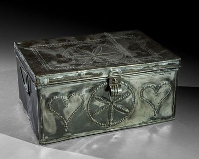une boîte en métal décorée de cœurs, posée sur une table