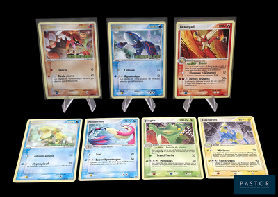 Plusieurs cartes Pokémon sont disposées sur une table avec un fond noir.